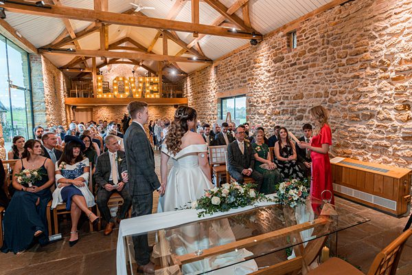 Wedding ceremony in rustic stone hall with guests.