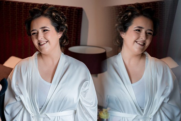 Woman smiling in white robe with mirror reflection.