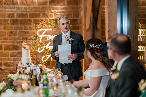 Man giving speech at wedding reception.