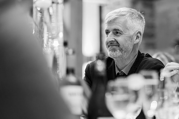 Man listening intently at social event, black and white photo.