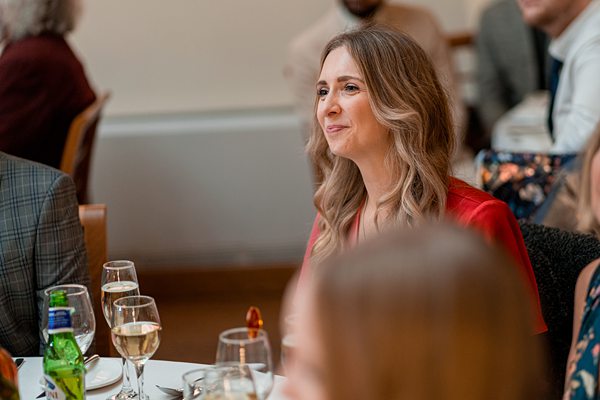 Woman smiling at formal dinner event.