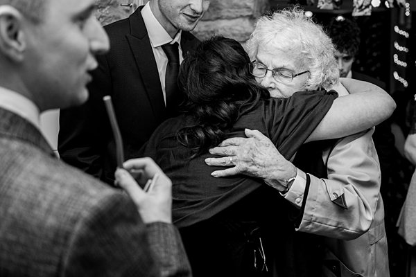 Elderly woman embracing young person at event.