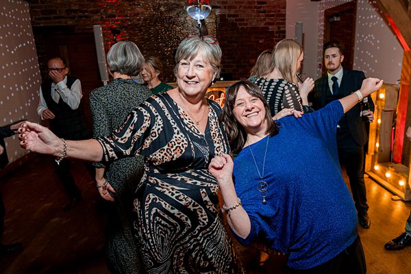 Two women dancing joyfully at a party.