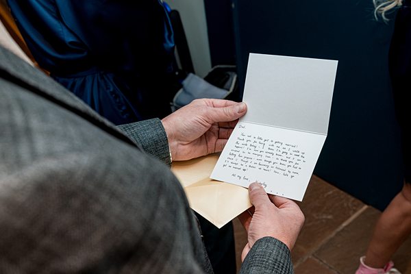 Person reading handwritten note from envelope.