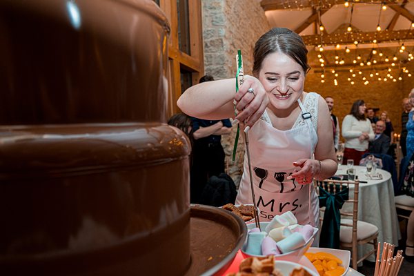 Woman enjoying chocolate fountain at event.