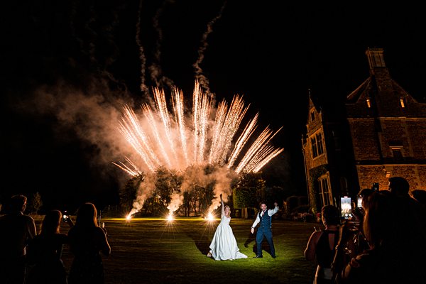 Wedding couple with fireworks display at night.