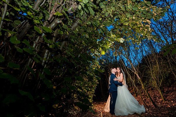 Couple embracing at forest wedding photoshoot.