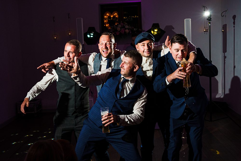Men enthusiastically dancing at a festive event.