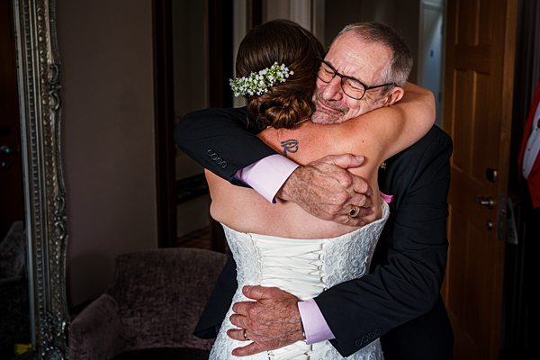 Bride embracing elder in heartfelt wedding hug.
