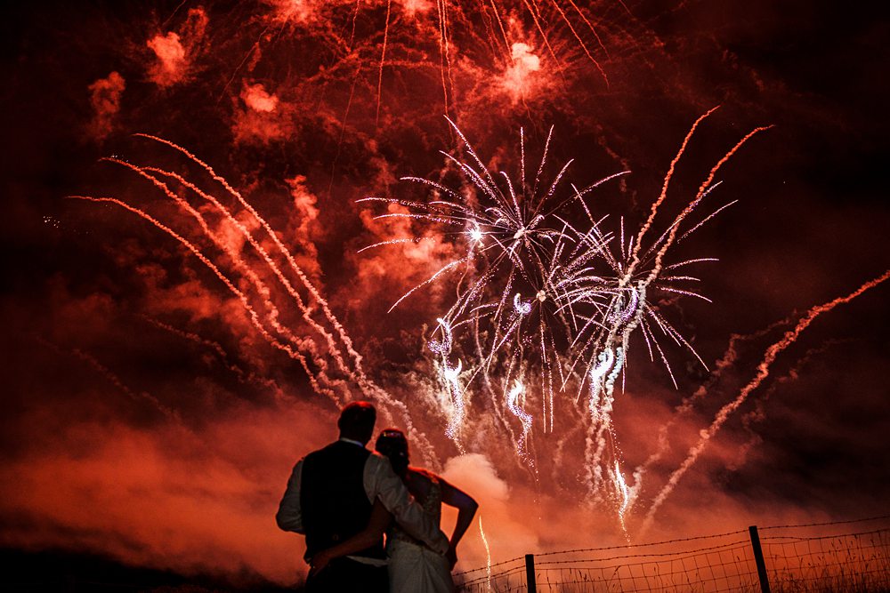 Couple watching vibrant fireworks display at night.