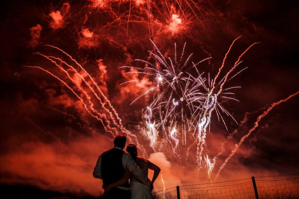 Couple watching fireworks display at night.