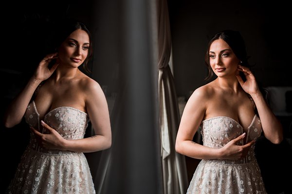 Woman in elegant dress reflecting in mirror.
