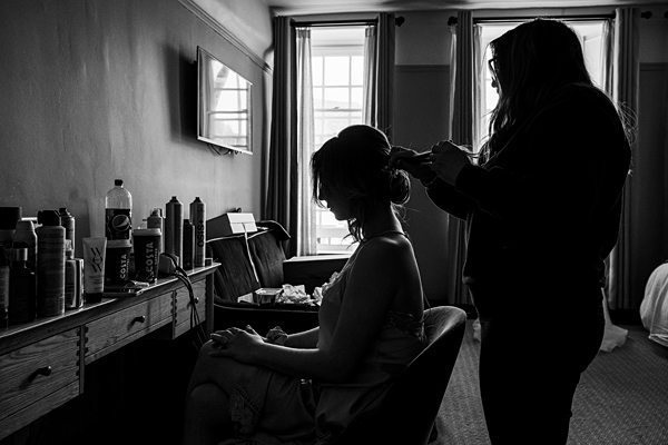 Hair stylist working on client in salon setting.