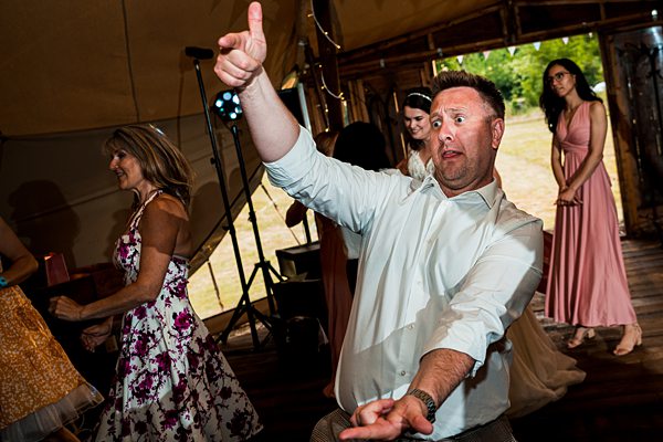 Man dancing enthusiastically at wedding reception.