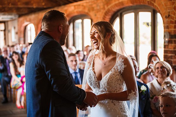 Joyful bride and groom holding hands at wedding.