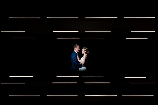 Couple embracing in silhouette with geometric light patterns.
