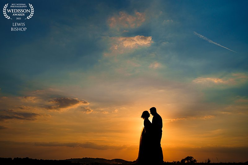 Silhouetted couple embracing at sunset.
