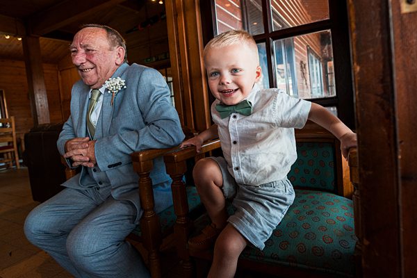 Elderly man and young boy smiling on vintage train.