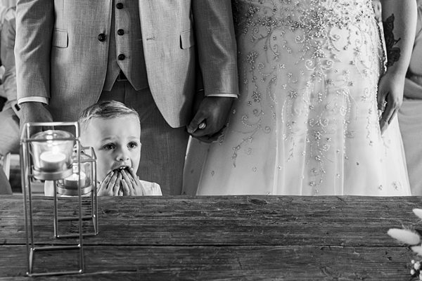 Child peeking at wedding table, couple standing.