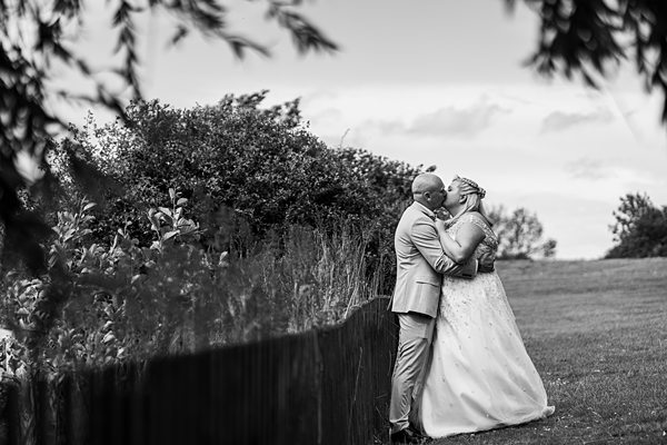 Couple embracing at countryside wedding, black and white photo.