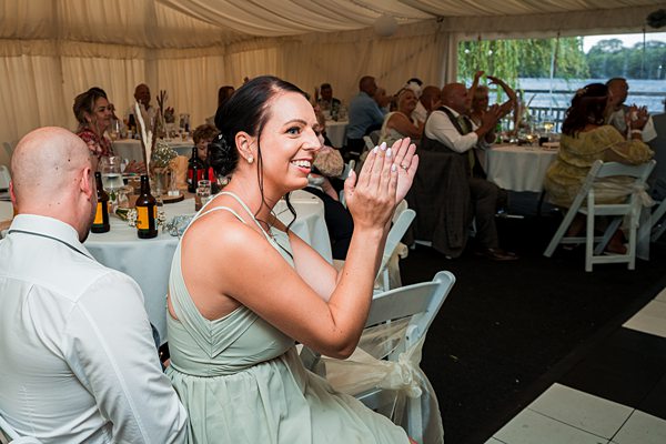 Woman clapping at wedding reception.