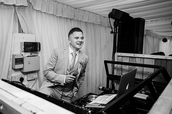 DJ in suit performing at a wedding event