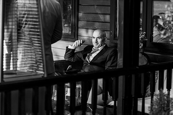 Man in suit sitting pensively in a vintage setting.