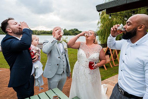 Wedding group doing a toast outdoors.