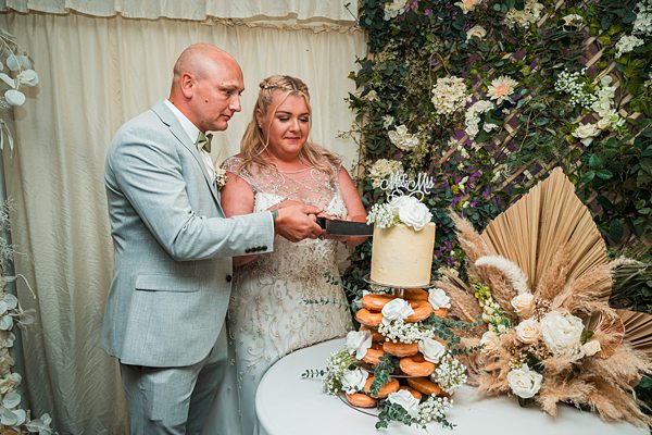 Couple cutting cake at wedding reception.