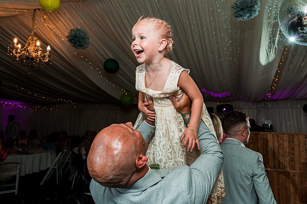 Child lifted in celebration at festive event.