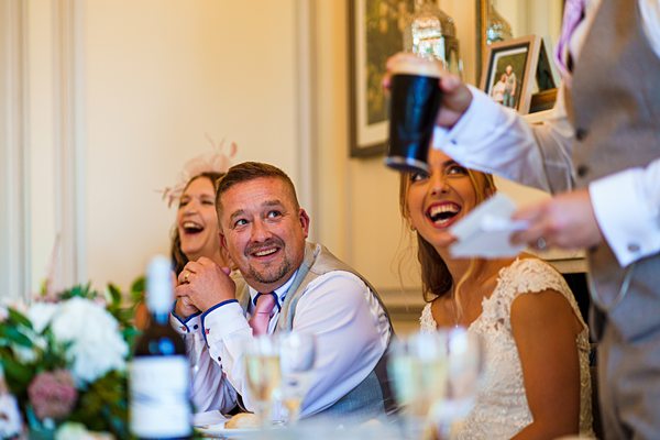 Wedding guests laughing during a speech.
