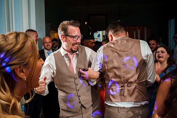 Men enjoying dance at lively wedding reception.