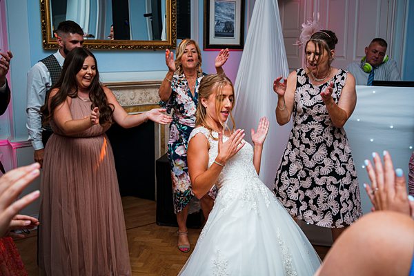 Bride dancing with guests at wedding reception.