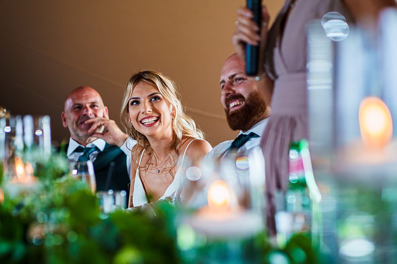 Joyful wedding reception with laughing bride and guests.