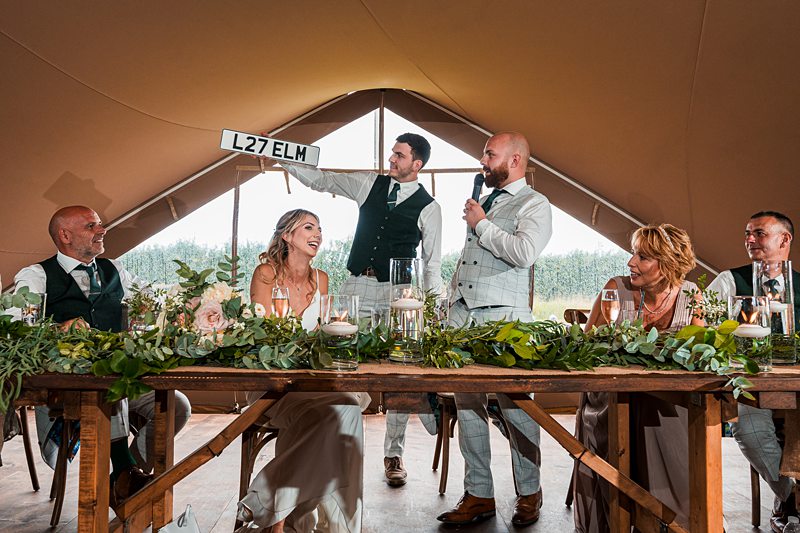 Wedding speech in rustic tent reception.