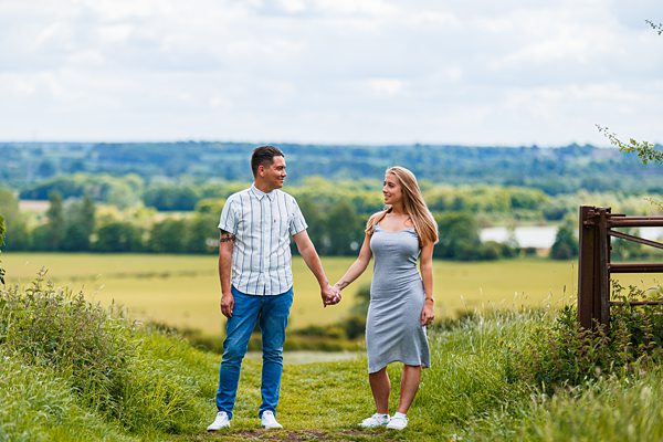 Couple holding hands walking in countryside.