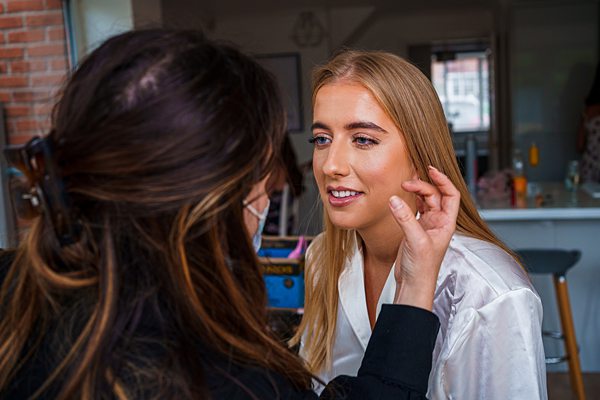 Makeup artist applying product to female client's face.