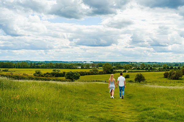 Couple walking in sunny, rural UK landscape