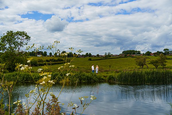 Couple walking by scenic lake in countryside.