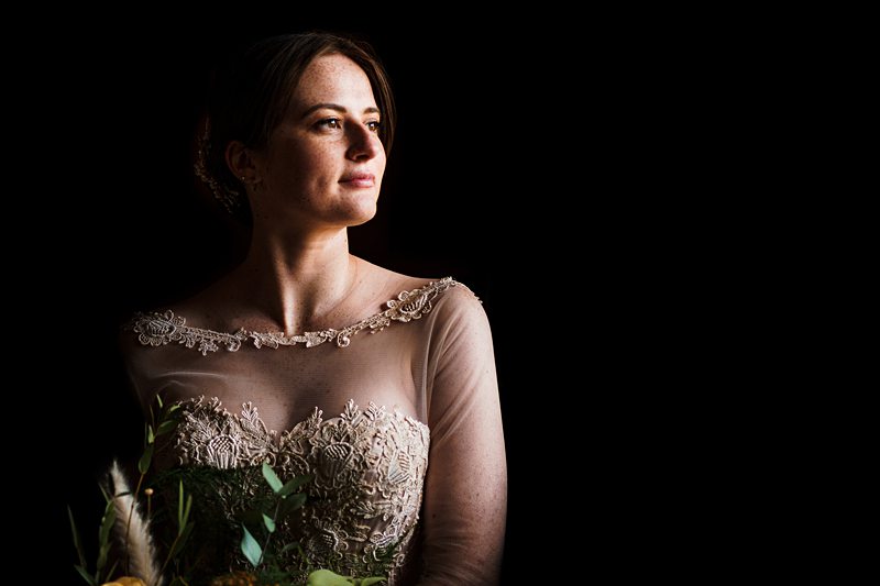 Bride in elegant dress with contemplative expression.