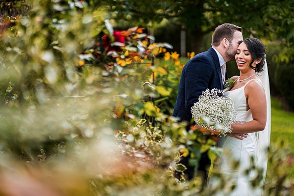 Couple embracing at garden wedding ceremony.