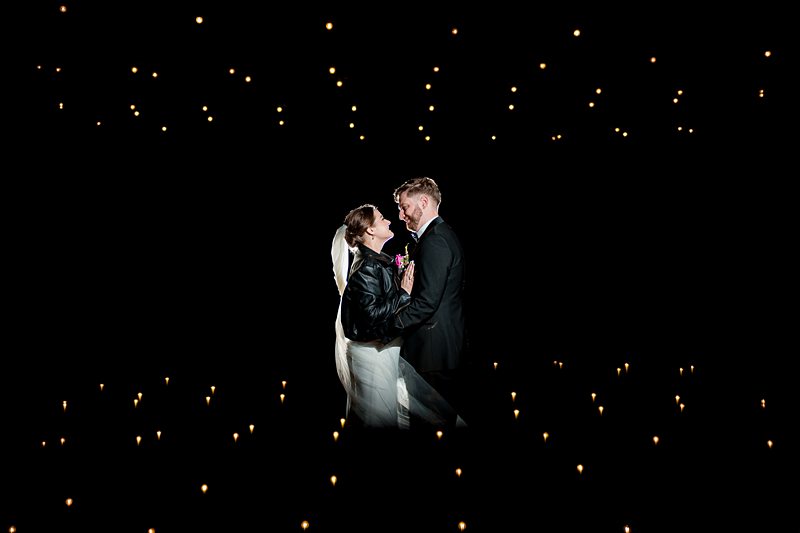 Couple sharing intimate moment under starry lights.