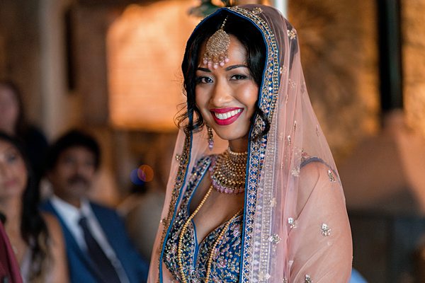 Smiling bride in traditional Indian wedding attire.