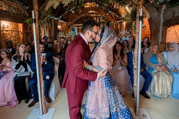Couple embracing at multicultural wedding ceremony.