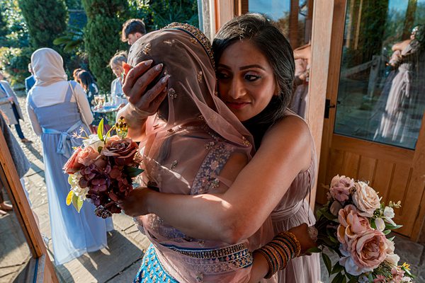 Traditional Indian wedding hug with bouquets.