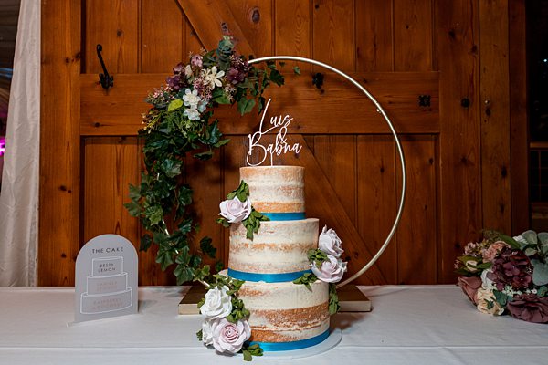 Elegant wedding cake with floral decoration and hoop topper.