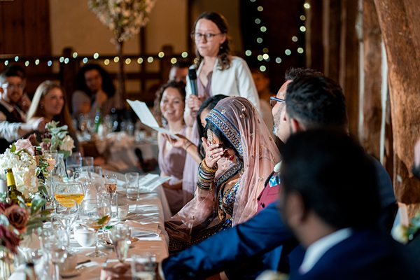 Wedding guest enjoying speech at multicultural reception