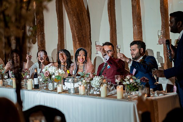 Wedding guests toasting at reception table.