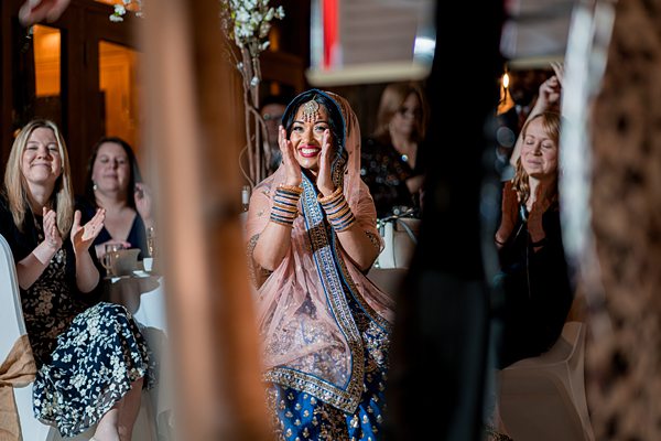 Joyful bride at multicultural wedding celebration.
