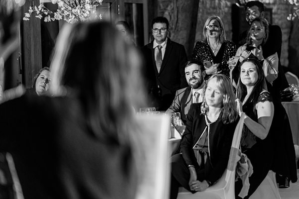 Guests watching speaker at wedding, black and white photo.
